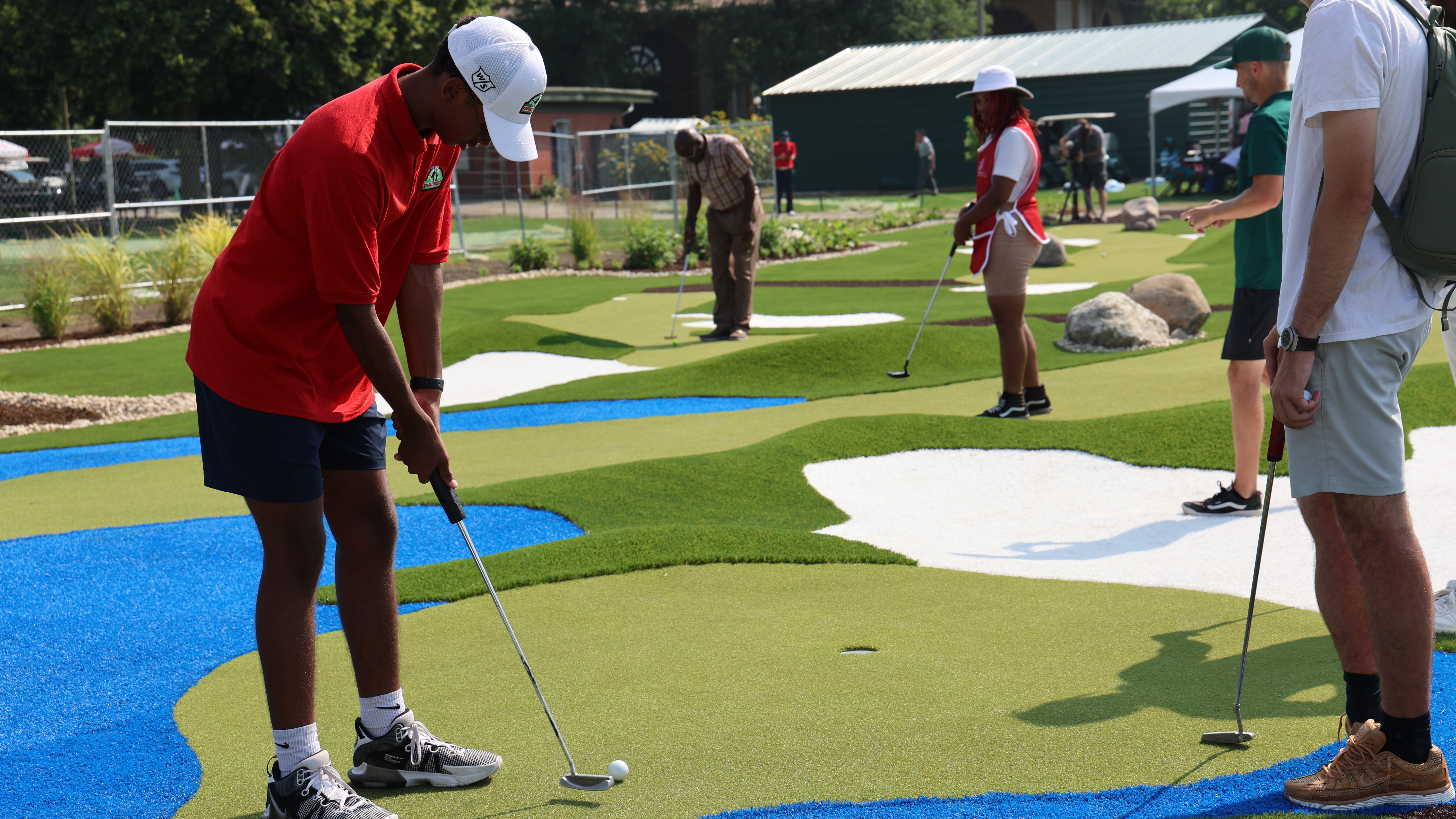 People putting on a colorful miniature golf course.